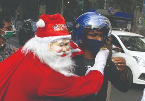 Santa presents helmets to errant riders in Park Street