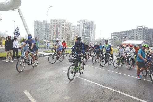 Cyclists ride through New Town to visit pandals