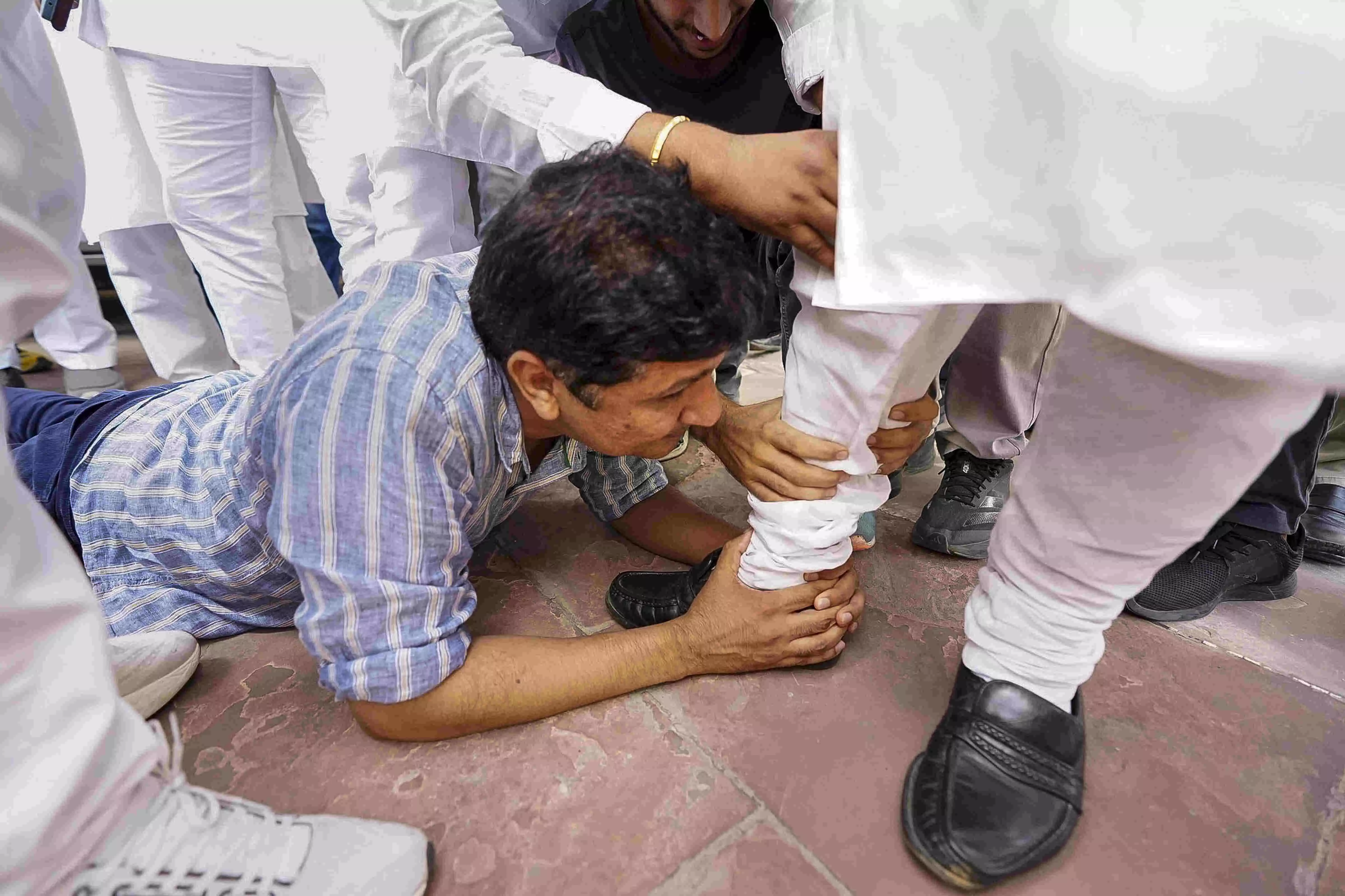 AAP leaders lay at BJP MLAs feet, accuse party of betrayal on bus marshals reinstatement AAP leaders lay at BJP MLAs feet, accuse party of betrayal on bus marshals reinstatement