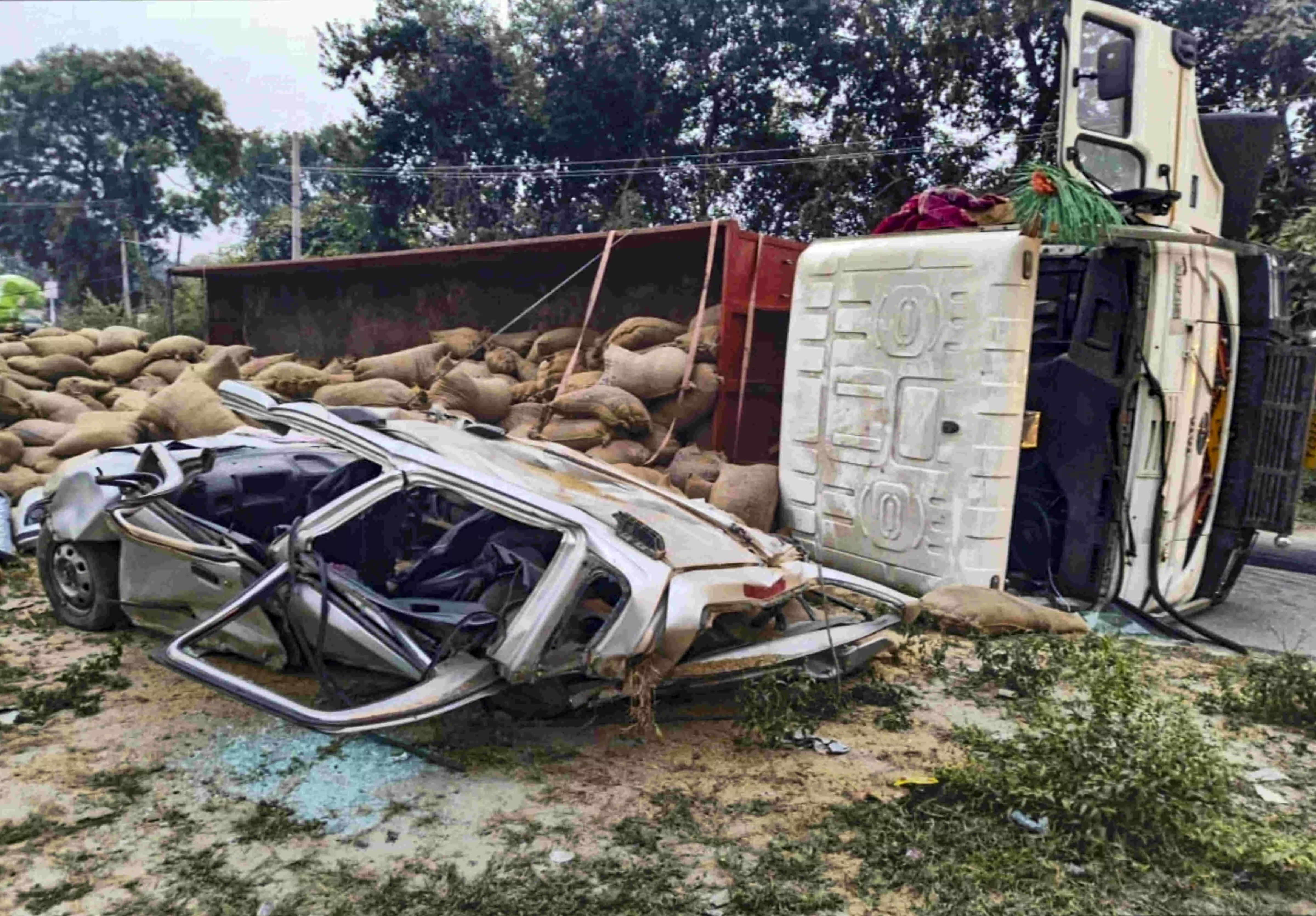 Paddy-laden truck overturns on car in UP, two killed Paddy-laden truck overturns on car in UP, two killed